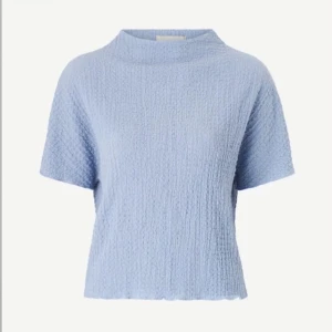 Ljusblå topp med struktur - Säljer en ljusblå topp med en fin textur och korta ärmar. Aldrig använt! Säljer på grund av att mamma köpte fel storlek💕 skriv för fler bilder! Köpt för 250kr