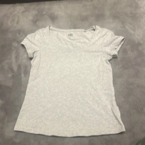 Ljusgrå t-shirt från 167 - Säljer en enkel och stilren ljusgrå t-shirt från 167. Den har en normal passform och korta ärmar, perfekt för vardagsbruk. T-shirten är tillverkad i ett mjukt och bekvämt material.