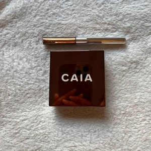 CAIA Loose Glow Bronzer och Eyeliner - Säljer en CAIA Loose Glow Bronzer i nyansen Alicante och en eyeliner i en metallisk brun färg. Bronzer kommer i en elegant fyrkantig förpackning. Bronzern är endast testad vid fåtal tillfällen. Eyelinern är helt ny och inte använd.