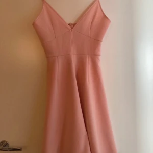 Rosa klänning från NLY One - Säljer en söt rosa klänning från NLY One. Klänningen har smala axelband och en v-ringad design. Perfekt för sommarens alla tillfällen. 💖