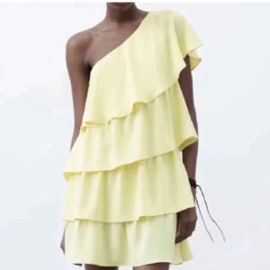 Gul oneshoulder klänning - Snygg gul oneshoulder klänning med volanger 