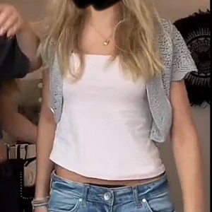 Grå stickad bolerotopp - Säljer en söt grå stickad bolerotopp med korta ärmar och ett fint hålmönster. Den är väldigt gullig och i bra skick!!