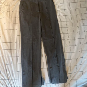 Grå kostymbyxor från NA-KD - Snygga grå kostymbyxor från NA-KD i storlek 36. Byxorna har en klassisk rak passform och är tillverkade i ett stilrent material. Perfekta för en elegant look.