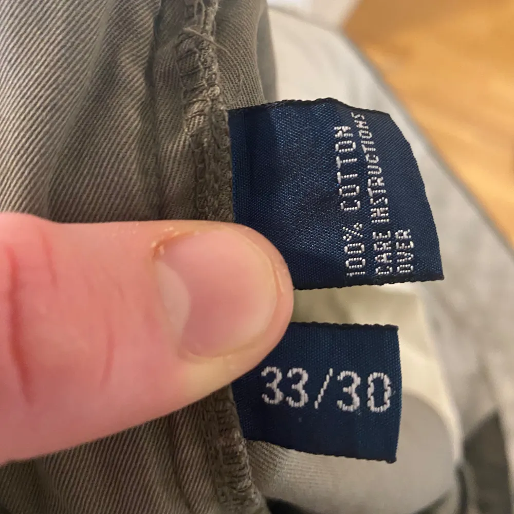 Säljer ett par stilrena grå chinos från Polo Ralph Lauren. Byxorna är tillverkade i 100% bomull och har en klassisk design med dragkedja och knappar. Perfekta för en avslappnad men ändå uppklädd look.. Farkut & Housut.