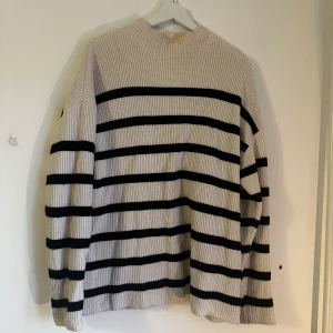 Randig stickad tröja - Säljer en snygg stickad tröja med breda svarta ränder. Beige/vit.