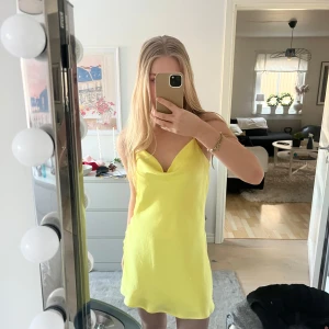 Gul axelbandslös klänning - Säljer en solig gul axelbandslös klänning med en enkel och stilren design. Perfekt för varma dagar och somriga tillfällen. Klänningen har en lätt och luftig passform.