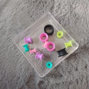 Färgglada töjningar i plast - Säljer ett set med färgglada töjningar i plast. Innehåller olika storlekar och färger som rosa, svart, grön och turkos. Perfekt för att mixa och matcha efter humör och stil.