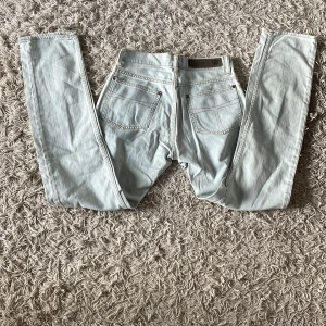 Ljusblå jeans från Tigger of sweden - Snygga ljusblå jeans från Tiger of sweden med en klassisk femficksdesign. De har en rak passform och är tillverkade i ett bekvämt denimtyg. Perfekta för en avslappnad stil.