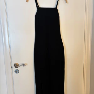 Svart klänning - Svart lång klänning från Gina tricot i storlek xs. Den har öppen rygg och två slitsar fram. Den är använd en gång🖤