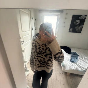 Beige leopardmönstrad stickad tröja - Säljer en beige stickad tröja med leopardmönster i mörkbrunt och svart. 