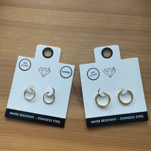 Guldpläterade hoops från Lovisa - Två par stilrena guldpläterade hoops från Lovisa, tillverkade i rostfritt stål. De är vattenresistenta och har en enkel design som passar perfekt för dig som gillar minimalistiska smycken. Helt oanvända! Båda paren för 200. 