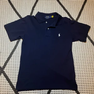 Ralph Lauren piké - Säljer denna mörkblåa Ralph lauren pikén. Den är endast använd någon enstaka gång och är i storlek S. Tveka inte med frågor!