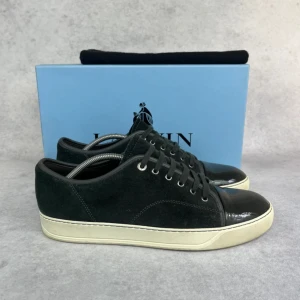 Lanvin DBB1 cap toe sneaker - – Condition: 9/10  - Size: 44/UK10  – What is included: Dustbag  – Retail price: 5000 + SEK  Please note that Lanvins fit big and our recommendation is to go one size down