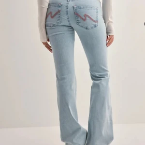 Ljusblå bootcut jeans med broderade bakfickor - Hej, har dessa Jeans från Nelly, de är endast använda 1 gång och är i nyskick! Köpte de för 699kr. Kan oxå sälja de för 500kr