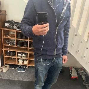 Marinblå Burberry hoodie - Säljer en mörkblå burberry hoodie, perfekt till hösten och även vintern! Materialet är otroligt mjukt och skönt mot huden, varm är den också. Sparsamt använd, mycket bra skick.