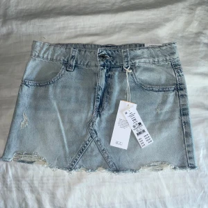 Ljusblå jeanskjol från Gina tricot  - Säljer en ljusblå jeanskjol från Gina Tricot med låg midja och rå kant nedtill. Kjolen har klassiska fickor fram och bak, samt snyggt broderi på bakfickorna. Perfekt för dig som gillar denim och coola detaljer. Jag har aldrig använt den och prislappen är kvar💓