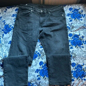 Svarta raka jeans med fem fickor - Snygga svarta jeans med klassisk femficksdesign och raka ben. Jeansen har normal passform och är tillverkade i slitstarkt denimtyg. Perfekta för dig som gillar en enkel och clean look. Passar till sneakers eller boots.
