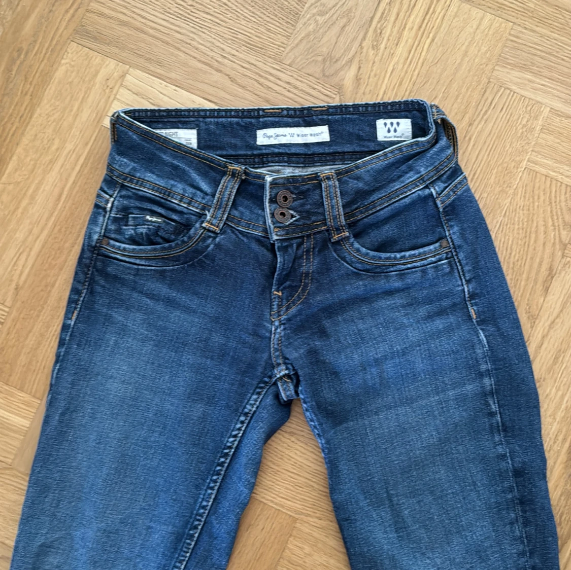 Blå jeans med dubbla knappar och låg midja