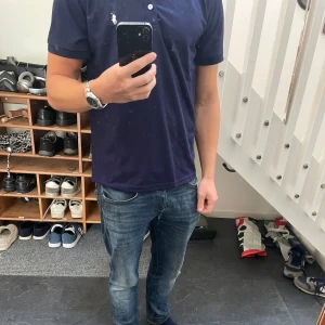Marinblå piké Ralph Lauren - Mörkblå polo t-shirt från Ralph Lauren med klassisk vit broderad logga på bröstet. Endast använd ett fåtal gånger, därav mycket bra skick!