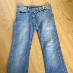 Ljusblå bootcut jeans från Vila - Säljer ett par ljusblå jeans från Vila med bootcut-modell. Jeansen har två knappar i midjan, klassiska fickor och snyggt slitna detaljer. Är i storlek M men är små i modellen 