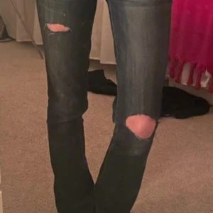 Mörkblå bootcut jeans med slitningar - Säljer ett par mörkblå bootcut jeans med slitna detaljer på knäna. Jeansen har klassisk femficksdesign och är i ett stretchigt denimtyg. Perfekta för en avslappnad och trendig look. Kom privat för mått eller bilder 🤗