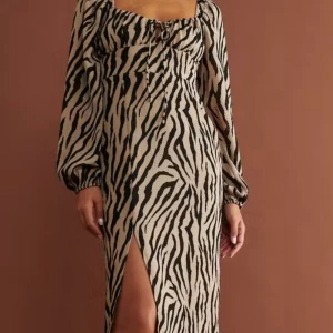 SÖKER! Strl 38/40. Zebramönstrad klänning från Gina Tricot - SÖKER!! Snygg långklänning med zebramönster i beige och svart. Klänningen har långa puffärmar.