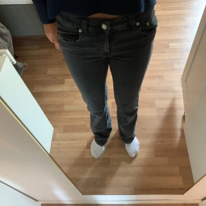 Svarta bootcut low waist jeans från 157 - Säljer ett par gråa jeans från 157 med bootcut-modell inspirerad av 90-talet. Jeansen har klassisk femficksdesign, dragkedja och knapp framtill. Perfekta för dig som gillar en retrostil med lite vidare benslut.