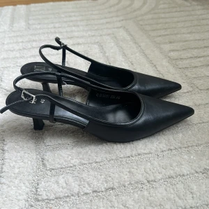 Svarta pumps med smal klack  - Säljer ett par svarta pumps med smal klack och spetsig tå. Aldrig använda.