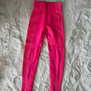 Ultra seamless tights från Gymshark - Säljer ett par rosa seamless tights från Gymshark med hög midja och ribbade detaljer längs sidorna. Perfekta för träning och har en tight passform som framhäver formen. Diskret Gymshark-logga på höften.