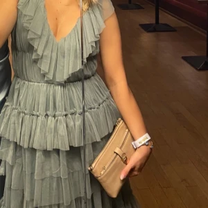 Ljusblå volangklänning med v-ringning - Säljer en ljusblå långklänning med flera lager volanger och djup v-ringning. Klämningen är från Lace and beads och är använd en gång! 