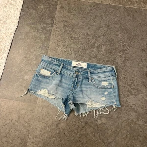 Ljusblåa Lågmidjade Hollister jeansshorts  - Sjukt snygga jeansshorts från Hollister 💓 Strl 24, motsvarar XS💓 I nyskick, lågmidjade, sitter väldigt fint på, perfekta till sommaren! Fina spets detaljer på framsidan och fina slitningar och fickor 