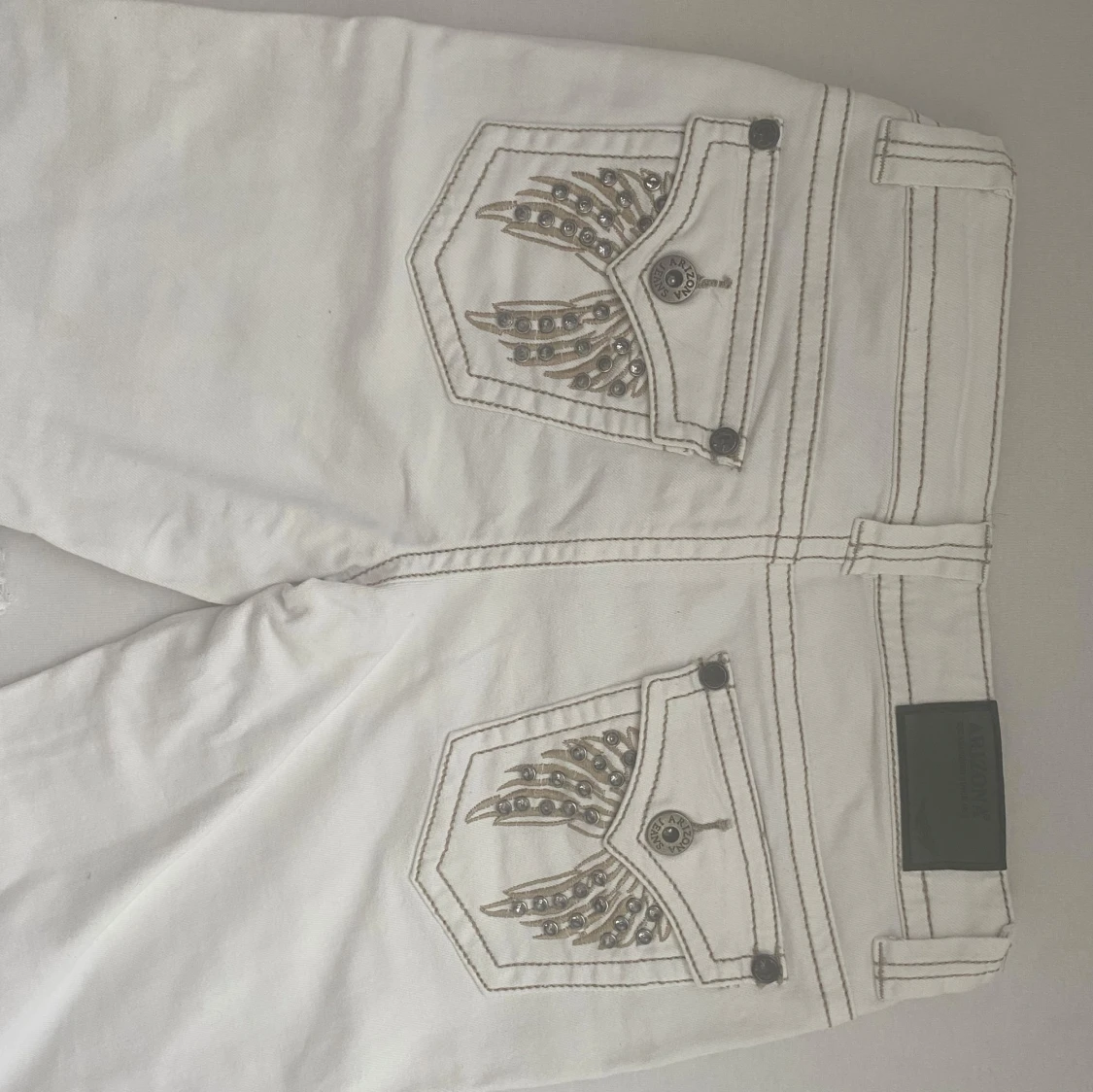 Vita lågmidjade flared jeansbyxor med broderade fickor - 1