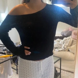 Svart offshoulder ribbad tröja - Säljer en svart ribbad tröja med offshoulder-design. Tröjan har långa ärmar och sitter snyggt på kroppen. Perfekt för dig som vill ha en enkel men trendig look. Tröjan är använd 1 gång, som ny!💖