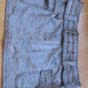 Y2k kjol grå - Grå kjol från tidigt 2000 tal från vila. Storlek medium och gjord i bomull och floss. 42cm i midjan när spänd på det största och 32cm lång!