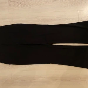 Svarta kostymbyxor från Cubus - Säljer ett par klassiska svarta kostymbyxor från Cubus. Byxorna har rak passform och är perfekta för en stilren look. De är tillverkade i ett mjukt material och har en enkel design utan synliga detaljer.