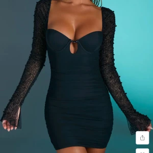 Svart tight långärmad klänning med pärldetaljer - Säljer denna super snygga klänning som är endast använd en gång på nyår för ett år sån, den är storlek 6 men skulle säga att den är en small eller 36. Super snygg till festligheter eller festivaler perfekt med om du inte vill betala frakten på hemsidan, den kostar 800 kr på hemsidan sen plus frakt hör av er om ni har frågor