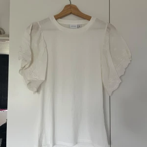 Söt topp - Vit topp från Vila med ärmar i broderi anglaise. Storlek M och oanvänd. Säljer då den inte kommer till användning. Pris är diskuterbart  Hör av dig vid frågor
