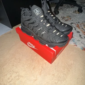 Nike Air Vapormax Plus (NÄSTAN HELT NYA!) - Säljer ett par helsvarta Nike Air Vapormax som är nästan helt nya! Alltså i bästa skicket! Storlek 44 men passar 43 också.