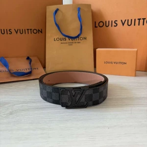 Lv bälte - Säljer ett stilrent svart bälte från Louis Vuitton med klassiskt rutigt mönster och LV-spänne i svart metall. Bältet har en insida i ljust skinn och är perfekt för dig som vill ha en exklusiv accessoar med ikonisk design. Helt nytt!!☺️☺️👍🏼👍🏼