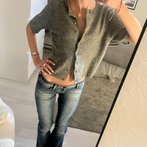 Grå stickad kofta med kort ärm - Kort grå stickad kofta med rund hals och korta ärmar. Har endast använts ett fåtal gånger. Priset går att diskutera🥰