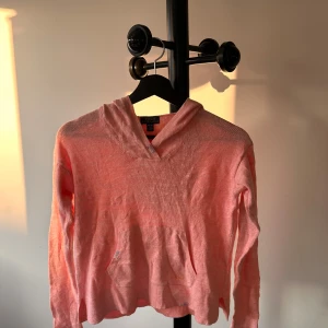 Rosa hoodie från Polo Ralph Lauren - Snygg ljusrosa hoodie från Polo Ralph Lauren med broderad RL-logga på fickan. Tröjan är stickad i bomull, har huva och känguruficka framtill. Perfekt för dig som gillar en chill och avslappnad stil.