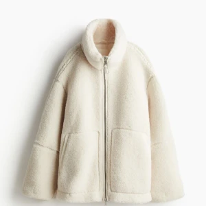 Beige teddyjacka från HM - Supermjuk och oversized teddyjacka i beige med hög krage och stora fickor framtill. Säljer denna då den aldrig kom till användning i vintras. Prislapp finns kvar 