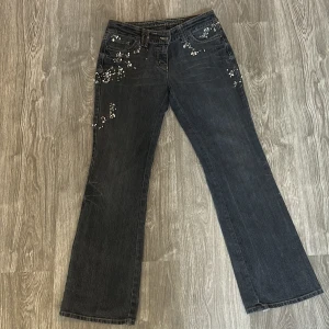 Blommiga bootcut jeans från Next - Stentvättade bootcut jeans från Next med broderade blommor och pärldetaljer på fickor och ben. Snygga kontrastsömmar och texten 'love found, dreams discovered' broderad i midjan. Säljs för att dom inte används i storlek 38 (uk 12)