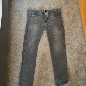 Replay Anbass grå slim jeans - Snygga grå jeans från Replay, modell Anbass med slim fit. Säljer dem här stilrena Replay jeansen. Jag säljer dem här för att jag har vuxit ur dem. Ny pris 1500kr säljer dem endast för 400kr. Frågor och funderingar tveka inte på höra av er!