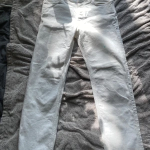 Vita raka jeans från Filippa K Jeans - Snygga vita jeans från Filippa K Jeans med klassisk femficksdesign och raka ben. Jeansen är i bomull och har en stilren look som passar till det mesta. Jeansen har små gröna fläckar (se bild), men de går nog bort med lite vanish.