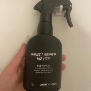 Lush Honey I Washed The Kids Body Spray - Säljer en Lush Honey I Washed The Kids body spray i svart plastflaska med spraymunstycke. Doften är söt med toner av honung och kola, samt en fräsch twist av brasiliansk apelsinolja. Flaskan rymmer 200 ml och är vegansk. ENDAST TESTAD (tagit 2 sprut). Som helt ny. Ord pris 395