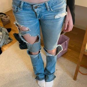 Ljusblå ripped jeans bootcut - Säljer ett par ljusblå jeans med  slitningar och hål över låren och knäna. Modellen är bootcut med normal passform. Jeansen har låg midja och är skit snygga!!!! w23 l33, men passar även w/24,25.