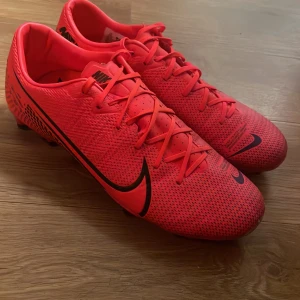 Nike fotbollsskor i neonröd, stl 43 - 9/10 bra skick Snygga neonröda Nike fotbollsskor med svarta detaljer och snörning. Skorna har en smidig och lätt ovandel i syntetmaterial och mönstrad sula med dobbar för bra grepp på planen. Perfekta för dig som vill sticka ut på matchen! Kan möts up inom stockholm vid snabb äffär kan priset sänkas lite mindre