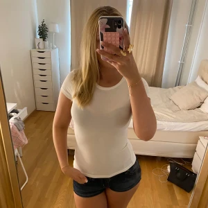 Vit tight t-shirt i bomull - Säljer en enkel och fräsch vit t-shirt med tight passform. T-shirten har korta ärmar och rund halsringning, perfekt för en clean och stilren look. Materialet känns mjukt och skönt mot huden, och den passar grymt till både jeans och shorts.