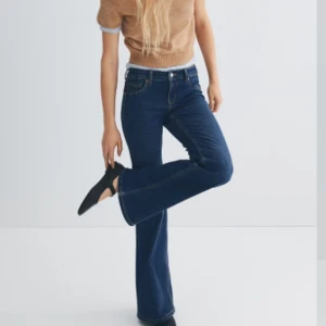 Mörkblå bootcut jeans - Snygga mörkblå bootcut jeans med klassisk femficksdesign. Jeansen har en låg midja och en bekväm passform som framhäver benen. Perfekta för en avslappnad stil.